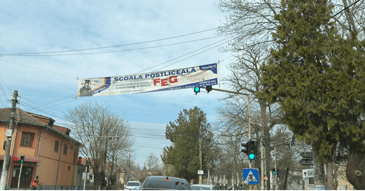 „Inginerie” la Roșiori de Vede: Un banner publicitar acoperă semaforul de la Anastasescu